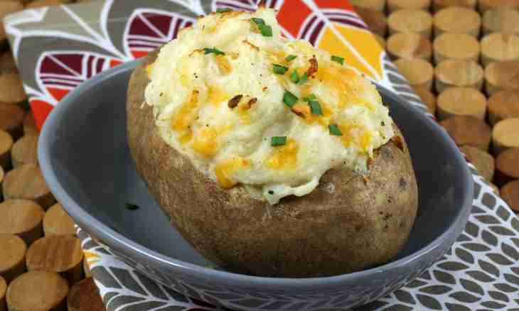 The baked potato with cheese and greens in the multicooker