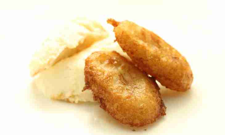 Fried bananas in batter with ice cream, crumpled and red currant