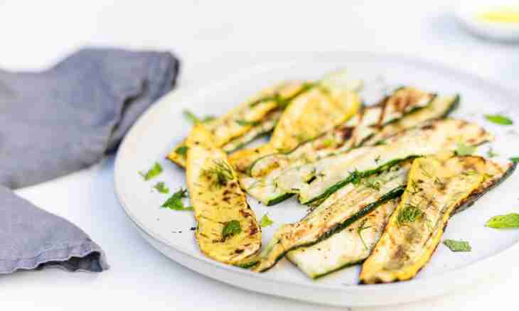 Zucchini on a grill with mint, garlic and a lemon